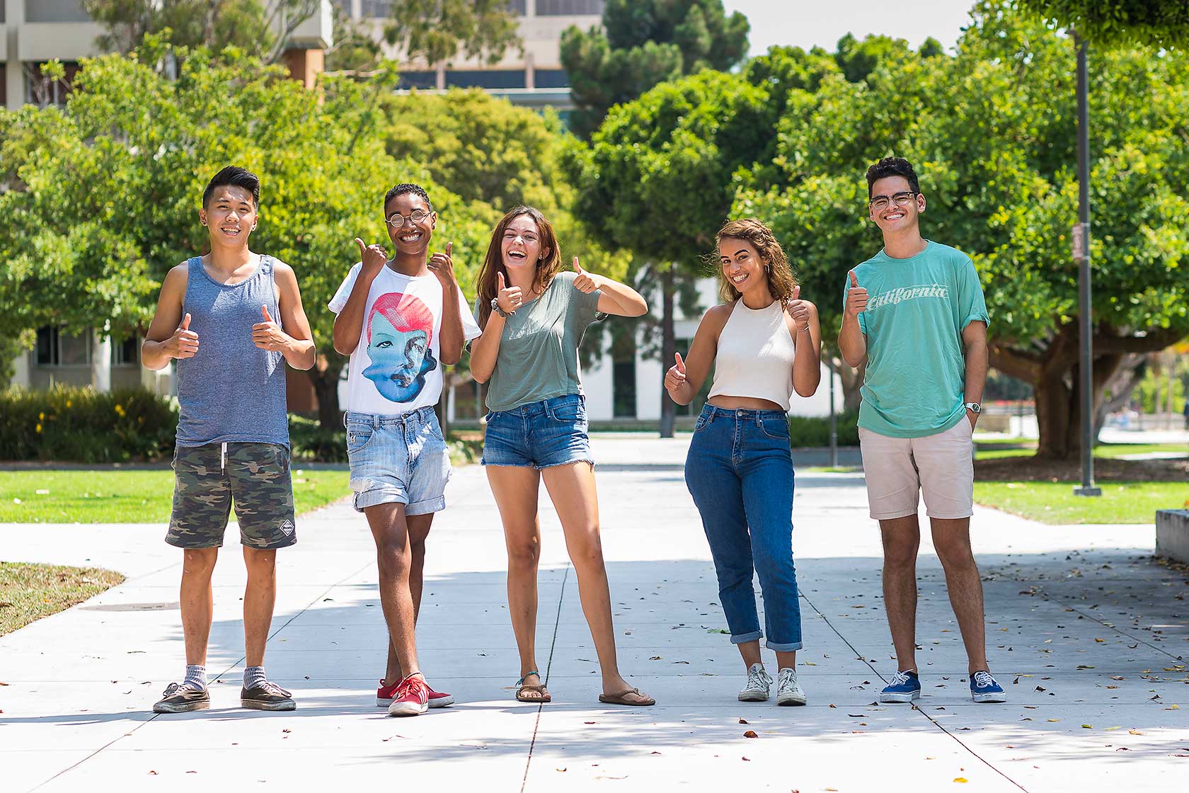 Group of students standing together with thumbs up